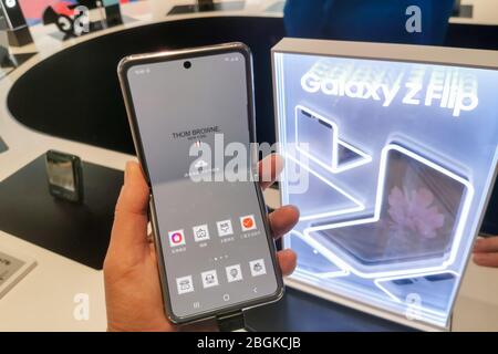 Un cliente possiede un modello di Samsung Galaxy Z Flip, uno smartphone pieghevole basato su Android che è esaurito il primo giorno, presso un'ammiraglia Samsung st Foto Stock