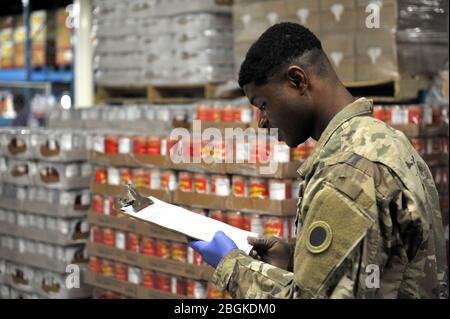 Soldato della Guardia Nazionale dell'Esercito degli Stati Uniti, SPC. Jacque Elama, assegnata al Reggimento della Fanteria della Guardia Nazionale dell'Ohio, 37a squadra di combattimento della Brigata della Fanteria, esamina una richiesta di ordine alimentare, da parte di una dispensa di cibo della chiesa locale, presso la Toledo Northwestern Ohio Food Bank, 23 marzo 2020. Quasi 400 membri della Guardia Nazionale dell'Ohio sono stati attivati per fornire missioni umanitarie a sostegno degli sforzi di soccorso del COVID-19, continuando la lunga storia della Guardia Nazionale dell'Ohio di sostenere gli sforzi umanitari in tutto l'Ohio e la nazione. Foto della Guardia Nazionale aerea di Senior Master Sgt. Beth Holliker. Foto Stock