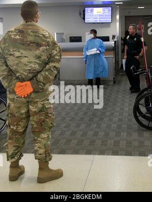 Florida Guardia Nazionale SPC. Joe Morales-McCullers, XIII Army Band Miramar Flar, attende i passeggeri in arrivo dalla zona dei Tri-state all'Aeroporto Internazionale di Fort Lauderdale-Hollywood, 25 marzo 2020. La XIII Army Band ha completato diverse missioni durante la risposta del COVID-19. (Foto dell'esercito DEGLI STATI UNITI di Sgt. Leia Tascarini) Foto Stock