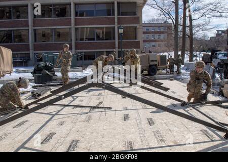 Soldati di Charlie Company (Medical), 186 Brigade Support Battaglione, 86th Fanteria Brigade Combat Team (Mountain), Vermont Army National Guard, allestire tende per un centro di triage al di fuori della University of Vermont Medical Center Emergency Room, 24 marzo. I medici assisteranno il personale ospedaliero a classificare i pazienti in base alle loro esigenze in caso di afflusso di pazienti. (Foto di U.S. Army Sgt. 1st classe Jason Alvarez, Vermont National Guard) Foto Stock