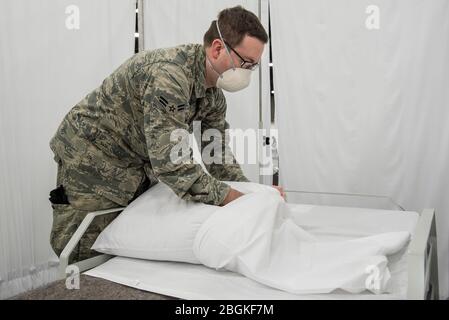 Airman i Classe Trevor Johnson della 123a Civil Engineer Squadron della Guardia Nazionale del Kentucky Air custodie cuscini per una struttura di cura alternativa al Kentucky Fair and Exposition Center di Louisville, Ky., 14 aprile 2020. Il sito, che dovrebbe essere operativo nell'aprile 15, tratterà i pazienti affetti da COVID-19 se gli ospedali dell'area superano la capacità disponibile. La postazione inizialmente offre assistenza per un massimo di 288 pazienti ed è scalabile fino a 2,000 letti. (STATI UNITI Foto della Guardia Nazionale aerea di Dale Greer) Foto Stock