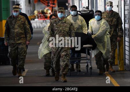 Esercito (cappellano) maggiore Ivan Arreguin, e altri soldati scortano i resti di un veterano morto da COVID19 mentre è stato trattato alla Javits New York Medical Station, eretta al Jacob Javits Convention Center a New York City, 19 aprile 2020. Membri militari attivi, soldati della Guardia Nazionale dell'Esercito di New York e personale che sono membri del servizio precedente dell'esercito resi onori. ( foto della Guardia Nazionale dell'aria degli Stati Uniti di Patrick Cordova maggiore) Foto Stock