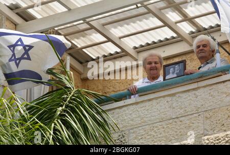 (200422) -- MODIIN, 22 aprile 2020 (Xinhua) -- i sopravvissuti all'olocausto Dmitry Kazavchinski (R), 85, e sua moglie Svetlana, 80, mostrano una foto a casa propria, in mezzo alla pandemia COVID-19 nella città centrale israeliana di Modiin, il 21 aprile 2020. Mentre Israele combatte il COVID-19, quest'anno il giorno commemorativo annuale dell'Olocausto assume un volto diverso. Il giorno dell'Olocausto di Israele è solitamente pieno di cerimonie. Il principale si tiene a Yad Vashem, il centro mondiale della memoria dell'Olocausto, a Gerusalemme. Una sirena di due minuti attraversa tutto il paese al mattino e tutto arriva a una sta Foto Stock