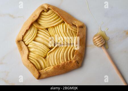 Galette di mele, torta con frutta e miele, dolci su tavolo in marmo, vista dall'alto Foto Stock