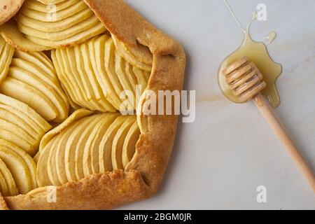 Galette di mele, torta ravvicinata con frutta e miele, dolci su un tavolo in marmo, vista dall'alto Foto Stock