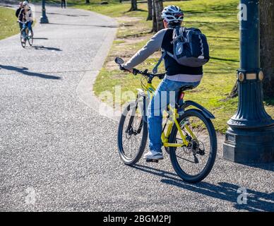 Un uomo in bicicletta pedala una bicicletta che passa sul vicolo autunnale preferendo uno stile di vita sano e attivo utilizzando la bicicletta e bicicletta come alternativa env Foto Stock