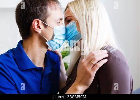 Storia d'amore famiglia marito moglie fidanzata ragazza in quarantena. Vita normale con coronavirus. Stile di vita COVID-19. Protezione antivirus in quarantena Foto Stock