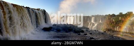 Panoramica con arcobaleno sopra i torrenti versanti della cascata della gola di Devils, parte delle cascate di Iguacu, Brasile, Sud America Foto Stock