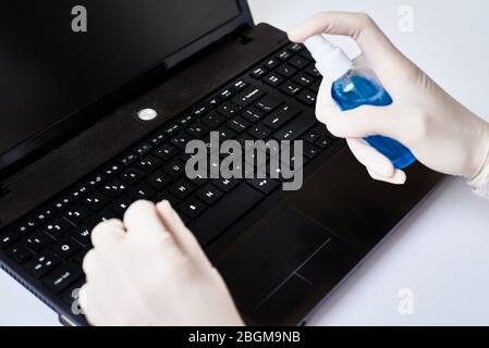 Disinfezione della tastiera del laptop prima di intervenire per proteggere il computer da coronavirus covid-19. Pulire il computer per il lavoro a casa Foto Stock
