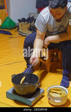 KHATGAL, MONGOLIA, 27 febbraio 2020 : cucinare i tradizionali khuushuurs in una casa di famiglia. Foto Stock