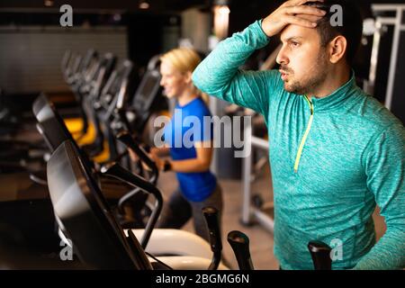 Atleta esausto uomo allenarsi in palestra Foto Stock