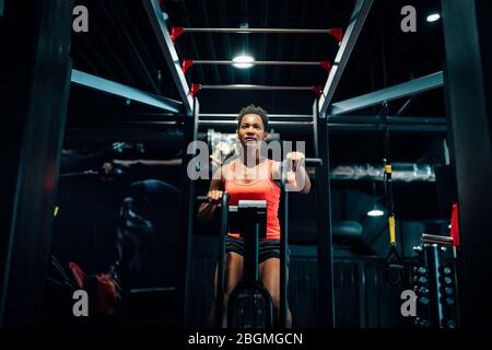 Femmina Fitness utilizzando aria bike cardio allenamento in palestra crossfit. Foto Stock