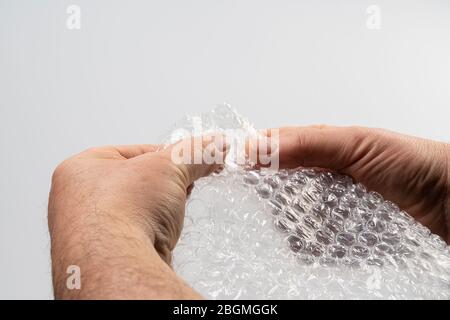 un foglio di plastica imbottitura a bolle nelle vostre mani Foto Stock