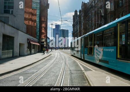 Un tram Metrolink che passa per il Midland Hotel su Lower Mosley Street con i blocchi torre di Deansgate Square in lontananza, Manchester, Regno Unito Foto Stock