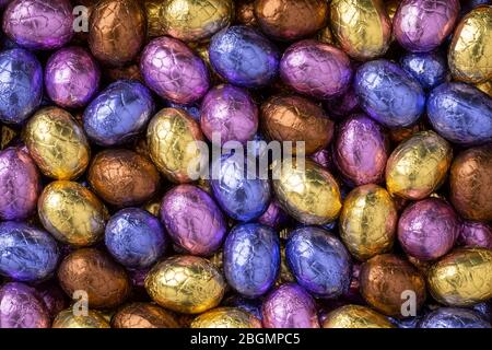Uova di pasqua al cioccolato in coloratissimo tinfoil primo piano su cornice intera Foto Stock