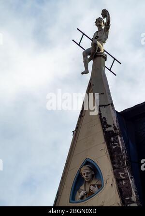 Una scultura spazzata camino sul tetto di una casa a riga. Foto Stock