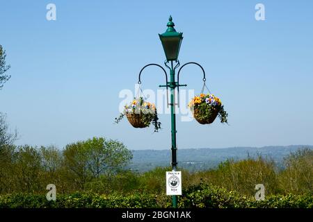 Cestini appesi su lampione con il vicino cartello e viste sulla valle di Medway a North Downs, Bidborough Ridge, Kent, Inghilterra Foto Stock