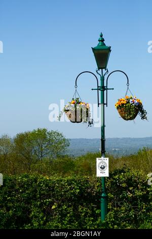 Cestini appesi su lampione con il vicino cartello e viste sulla valle di Medway a North Downs, Bidborough Ridge, Kent, Inghilterra Foto Stock