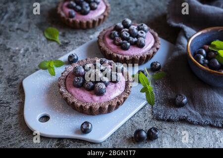 Tartine di cioccolato farcite con crema di mascarpone ai mirtilli e zucchero in polvere Foto Stock