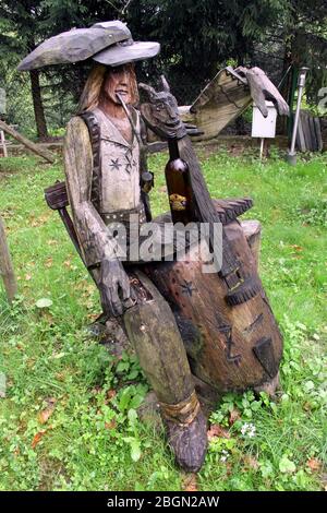 Mszana Dolna, Voivodato della Malopolska. Antica alveare di legno scolpita a forma di highlander locale. Costume folk regionale, contrabbasso Foto Stock