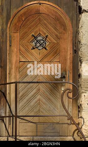 Una vecchia porta storica in legno su un vecchio muro in formato ritratto Foto Stock