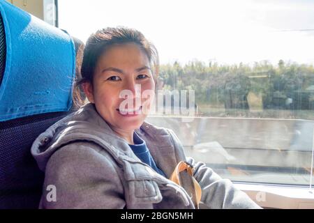 Una donna dalla Thailandia è seduta in Keisei Sky Liner che trasporta i passeggeri dall'Aeroporto Narita alla stazione della metropolitana di Ueno nel Cuore di Tokyo, Giappone Foto Stock