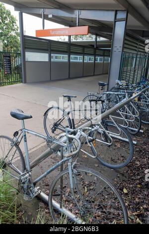 Le biciclette pendolari parcheggiate in un apposito portabiciclette accanto alla stazione ferroviaria di Turramurra sulla costa nord di Sydney in Australia Foto Stock