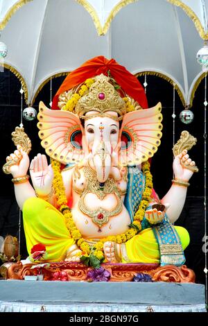 Statua dipinta a mano colorata del Dio indù indiano del Signore Idol Ganesha.Ganpati fatto di pietra di argilla di fango di terra o roccia per il culto Pooja in profondità Foto Stock