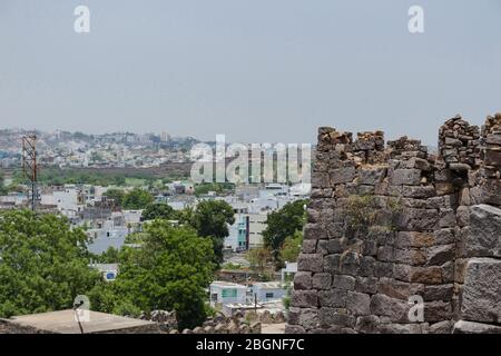 Rovine del forte di Golconda in contrasto con la città di Hyderabad. Questo è un contrasto netto tra il nuovo mondo e il vecchio impero mughal. Foto Stock