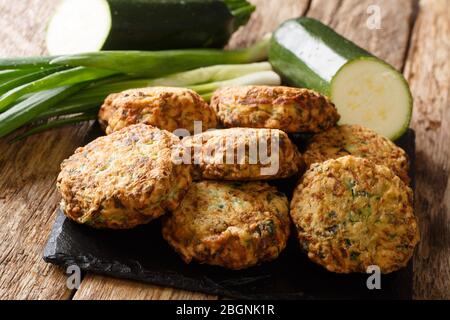 Gustose palle di zucchine greche con formaggio feta con ingredienti primo piano su un tabellone di ardesia sul tavolo. Orizzontale Foto Stock