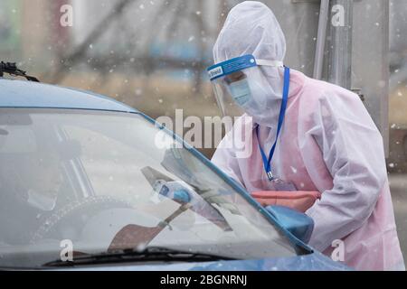 Suifenhe, provincia cinese di Heilongjiang. 22 aprile 2020. Un membro dello staff si attacca al suo posto per il controllo delle epidemie COVID-19 e per la prevenzione nella neve su una strada di ingresso della città a Suifenhe, nella provincia di Heilongjiang del nord-est della Cina, il 22 aprile 2020. Credit: Zhang Tao/Xinhua/Alamy Live News Foto Stock