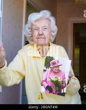 Kidderminster, Regno Unito. 22 aprile 2020. Peggy Lappage raggiunge la favolosa età di 100 anni giovani oggi! Le celebrazioni erano state programmate, ma a causa dell'istruzione di blocco "Casa fissa, protezione del NHS, salvare vite", tutti gli incontri hanno dovuto essere rinviati. Anche se in isolamento, i buoni desideri hanno mantenuto la sua linea telefonica calda tutta la mattina. Peggy è visto qui in possesso di una carta di compleanno molto speciale da sua Maestà la Regina e più tardi oggi alle 5 tutti i suoi vicini gentili saranno sorprenderla con canto collettivo di strada 'buon compleanno' in suo onore. Credit: Lee Hudson/Alamy Live News Foto Stock