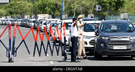 Nuova Delhi. 22 aprile 2020. Il personale della polizia si ferma e controlla un gran numero di veicoli in attesa in coda al checkpoint di Delhi-Noida durante il blocco nazionale in India il 22 aprile 2020. Il ministero federale della salute indiano il mercoledì sera ha detto che 12 nuovi decessi dovuti al COVID-19, oltre a 487 nuovi casi positivi, sono stati segnalati dalla mattina in tutto il paese, portando il numero di decessi a 652 e totale casi a 20,471. Credit: Partha Sarkar/Xinhua/Alamy Live News Foto Stock