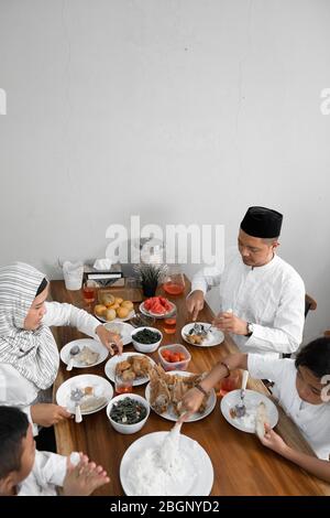 cena iftar sul ramadan. famiglia asiatica musulmana che rompe il digiuno insieme Foto Stock