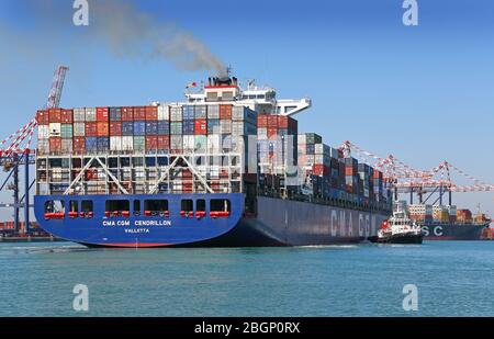 La nave container è posizionata da un rimorchiatore Foto Stock