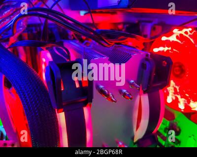 Moderno raffreddamento ad aria per computer con ventole LED multicolore con retroilluminazione, radiatori di raffreddamento, cavi, schede, primo piano, macro. Foto Stock