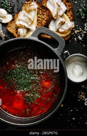 Un tradizionale borsch ucraino fatto da barbabietole, carote, maiale, patate, cavolo, erbe e aglio, primo piano. Foto Stock