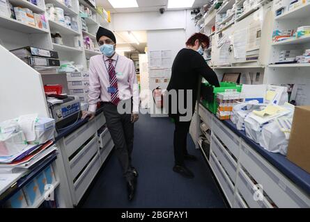 Farmacista Raj Matharu che lavora alla Broadway Pharmacy a Bexleyheath, Kent. Una nuova indagine istantanea sui farmacisti della Royal Pharmaceutical Society mostra che la maggior parte dei farmacisti non è in grado di mantenere le distanze sociali sul lavoro e che uno su tre non può ancora ottenere forniture continue di dispositivi di protezione individuale (DPI). Foto Stock