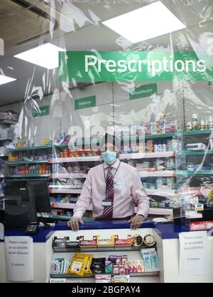 Farmacista Raj Matharu che lavora alla Broadway Pharmacy a Bexleyheath, Kent. Una nuova indagine istantanea sui farmacisti della Royal Pharmaceutical Society mostra che la maggior parte dei farmacisti non è in grado di mantenere le distanze sociali sul lavoro e che uno su tre non può ancora ottenere forniture continue di dispositivi di protezione individuale (DPI). Foto Stock