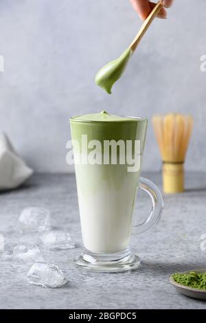 Dalgona Iced Matcha tè con tè montato e latte freddo. Gustosa bevanda virale nel tempo autoisolamento. Formato verticale. Foto Stock