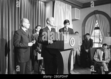 Il presidente Gerald R Ford, accompagnato dal Dr. Jonas Salk (a sinistra) e dal Segretario del Dipartimento di Salute, Istruzione e benessere F. David Mathews (a destra), annuncia il programma nazionale di immunizzazione dell'influenza suina nella sala stampa briefing, Washington, DC, 03/24/1976. Foto di Ricardo Thomas/Gerald R Ford Library Foto Stock