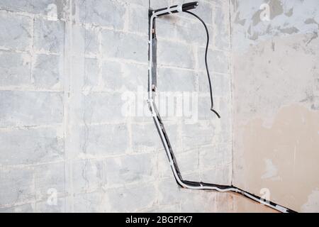 Installation of pipe channel for connecting air conditioner in concrete wall Foto Stock