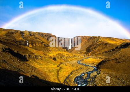 Incredibile paesaggio islandese con arcobaleno, cascate, montagne e fiume Foto Stock