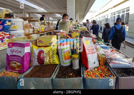 Venditore di mercato con i suoi prodotti e turisti al Bazaar Siyob o al Bazaar Siab, il più grande di Samarkand, Uzbekistan utilizzato dalla gente del posto in Asia centrale. Foto Stock