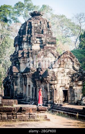 I turisti asiatici fanno il loro senso attraverso i templi antichi di Angkor Wat, Cambogia. Prendendo selfie, scalando scale, camminando i corridoi e prendendo Foto Stock