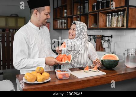 uomo e donna musulmana che hanno un po 'di frutta per la pausa cena a digiuno Foto Stock