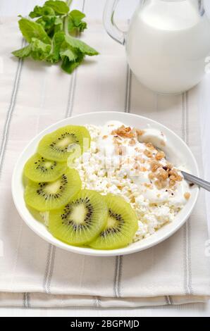 Formaggio casolare con yogurt e fette di kiwi. Colazione sana Foto Stock