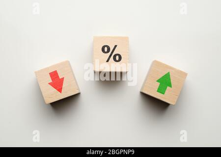 Concetto percentuale in finanza aumentare o diminuire con icone su blocchi di legno. Primo piano. Foto Stock