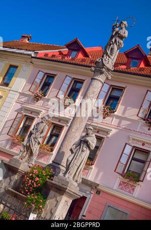 Slovenia, alta Carniola, Skofja Loka, Piazza Mestni trg, colonna della peste del 1751 con San Rocco, Vergine Maria con Gesù Bambino e Sant'Antonio. Foto Stock
