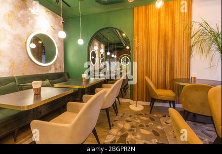 Interni moderni del ristorante con tavoli e divani e pareti di verde chiaro Foto Stock